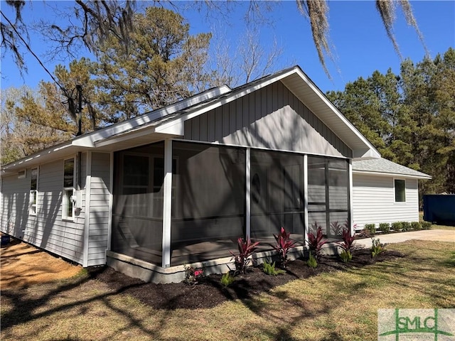 view of side of home featuring a lawn and a sunroom