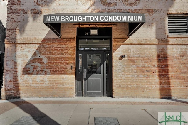 property entrance featuring brick siding