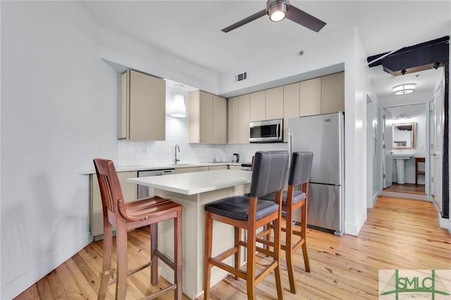 kitchen with visible vents, gray cabinets, a sink, appliances with stainless steel finishes, and light countertops