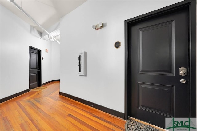 spare room with baseboards and wood finished floors