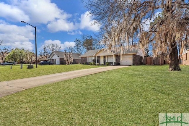 ranch-style home featuring driveway, an attached garage, a front yard, and fence