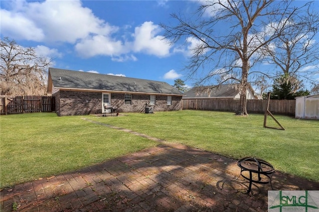 view of yard with a patio, a fire pit, and a fenced backyard