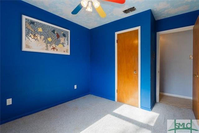 unfurnished bedroom with carpet flooring, a ceiling fan, visible vents, and a textured ceiling