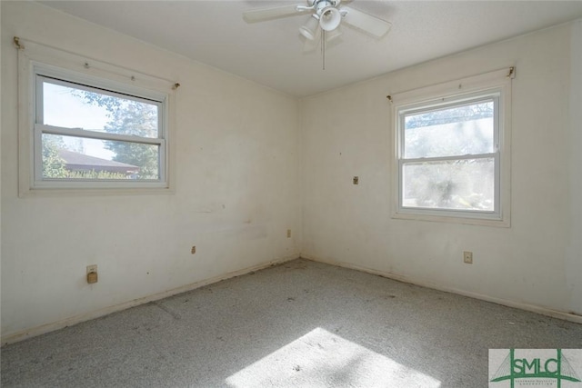 empty room featuring a wealth of natural light and ceiling fan