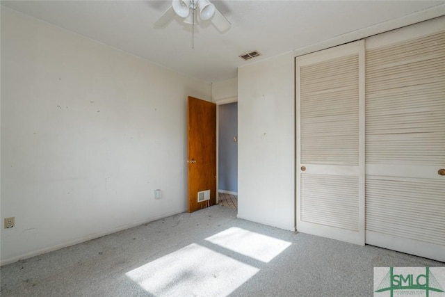 unfurnished bedroom with visible vents, a closet, and light carpet