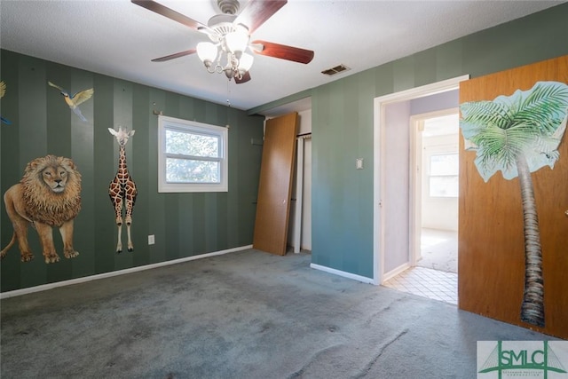 carpeted bedroom with visible vents, multiple windows, baseboards, and ceiling fan