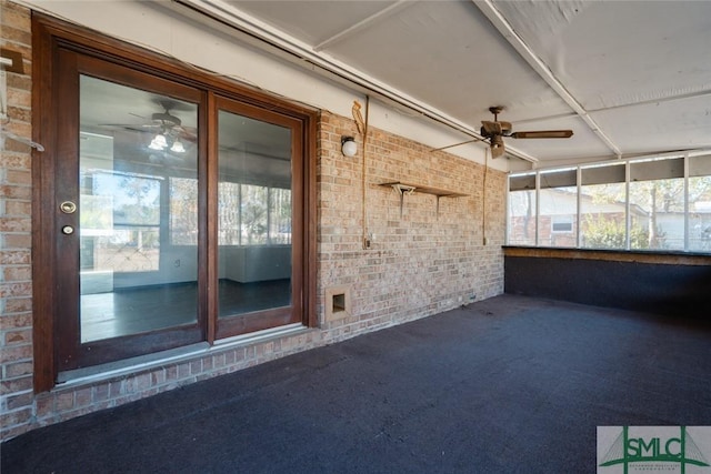 unfurnished sunroom featuring a ceiling fan