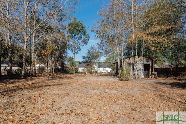 view of yard featuring a shed, an outdoor structure, and fence