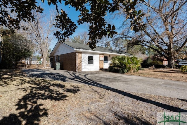 view of home's exterior featuring concrete driveway and fence