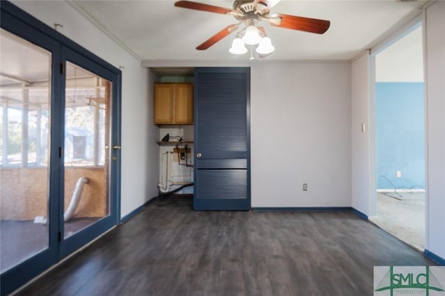 interior space with dark wood finished floors, ornamental molding, baseboards, and ceiling fan