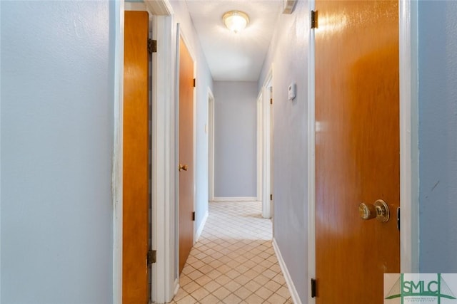 hallway featuring light tile patterned floors and baseboards