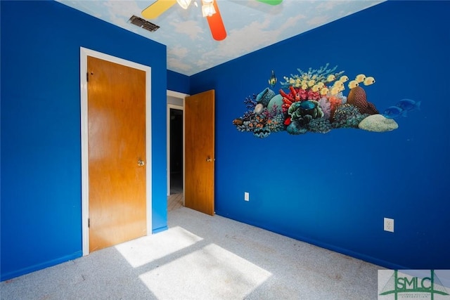 unfurnished bedroom featuring visible vents, carpet floors, and ceiling fan