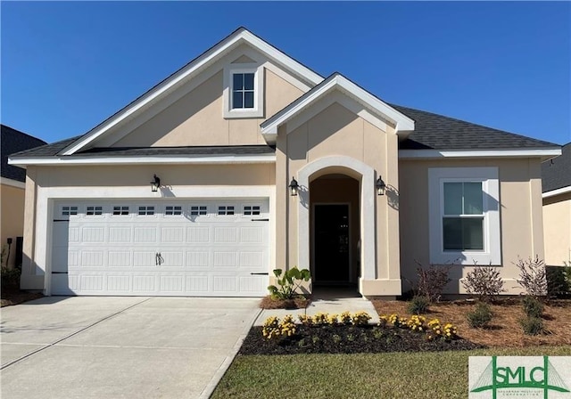 ranch-style house with stucco siding, an attached garage, concrete driveway, and a shingled roof