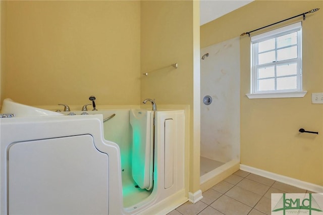 full bathroom featuring tile patterned flooring, a shower stall, washer / clothes dryer, and baseboards