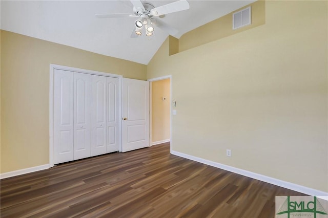 unfurnished bedroom with dark wood finished floors, visible vents, baseboards, and vaulted ceiling