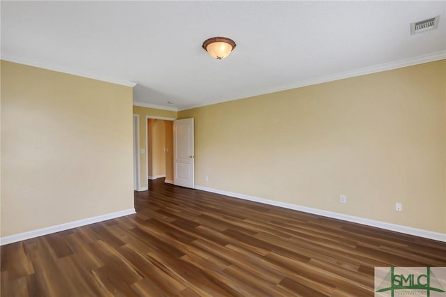 spare room featuring visible vents, ornamental molding, baseboards, and dark wood-style flooring