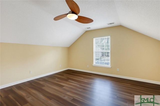 additional living space with visible vents, baseboards, a textured ceiling, a ceiling fan, and dark wood-style flooring