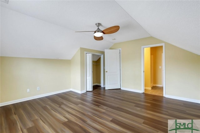 additional living space with a ceiling fan, wood finished floors, baseboards, lofted ceiling, and a textured ceiling