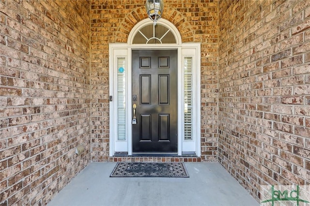 doorway to property featuring brick siding