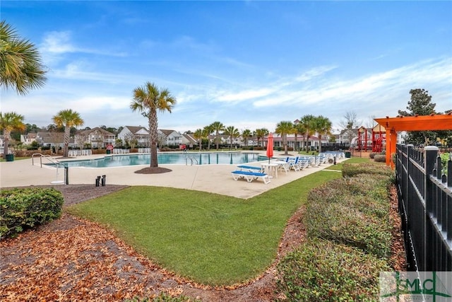 community pool with a lawn, a patio, and fence