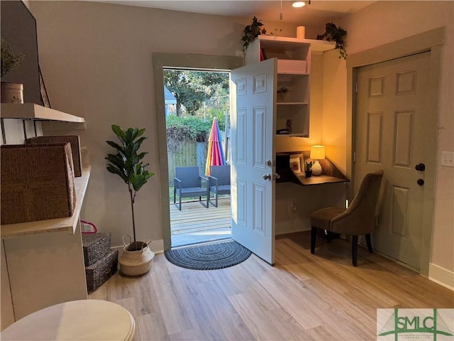 doorway to outside featuring light wood-type flooring and baseboards