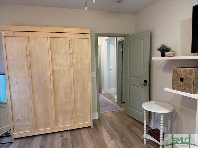 interior space with baseboards and wood finished floors