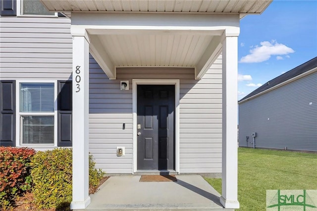 entrance to property with a lawn