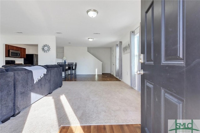 living area with wood finished floors and visible vents