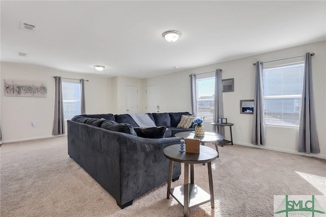 living room featuring light colored carpet, visible vents, and baseboards