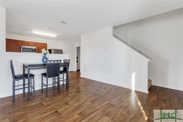 interior space with stairway, wood finished floors, visible vents, and baseboards