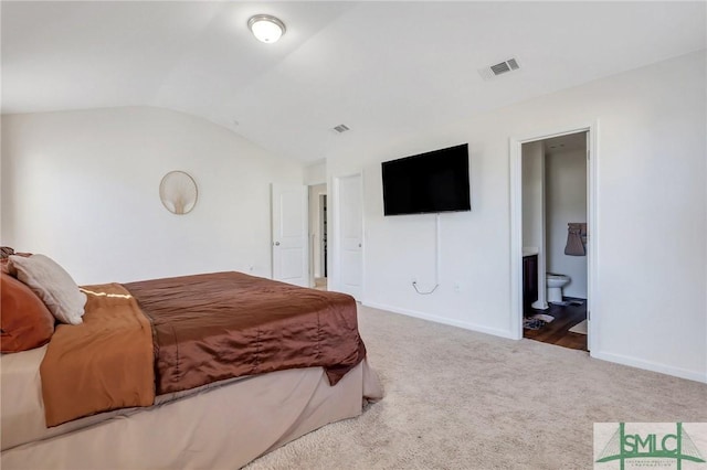 carpeted bedroom featuring vaulted ceiling, baseboards, visible vents, and connected bathroom