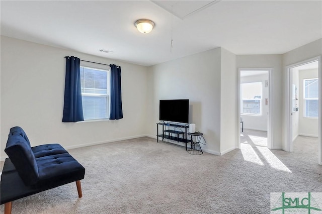 sitting room featuring baseboards, visible vents, attic access, and carpet