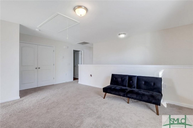 sitting room with baseboards, visible vents, attic access, and carpet