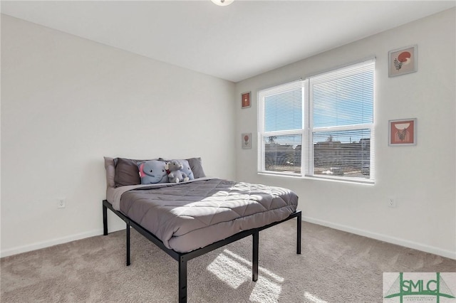 bedroom featuring light carpet and baseboards