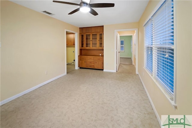 interior space with visible vents, baseboards, and ceiling fan