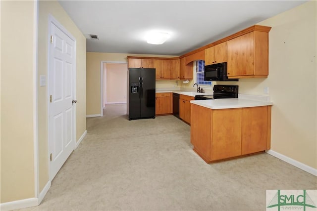 kitchen with visible vents, baseboards, a peninsula, black appliances, and light countertops