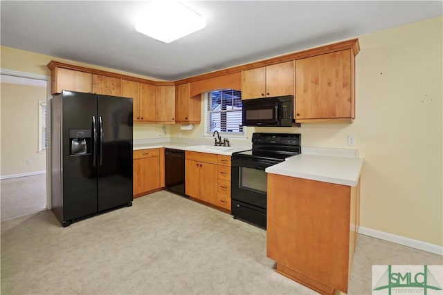 kitchen with a sink, baseboards, black appliances, and light countertops