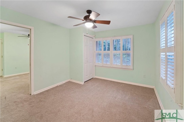 empty room featuring baseboards, a ceiling fan, and carpet floors