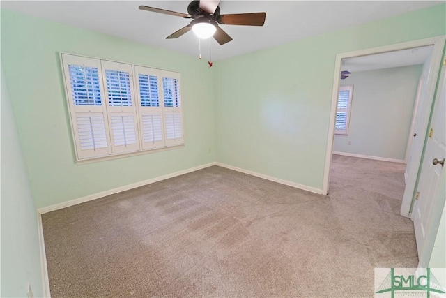 spare room featuring carpet flooring, baseboards, and ceiling fan