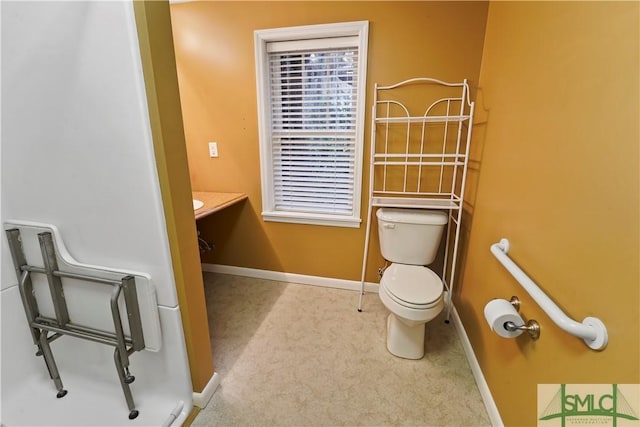 bathroom featuring baseboards and toilet