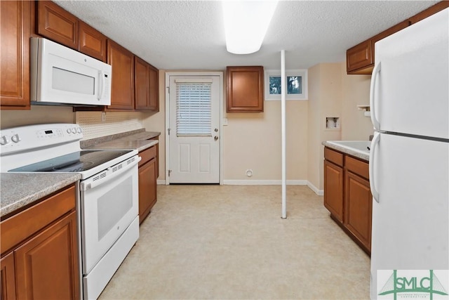 kitchen with a textured ceiling, white appliances, brown cabinetry, light countertops, and baseboards