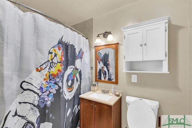 bathroom featuring toilet, vanity, and a shower with shower curtain