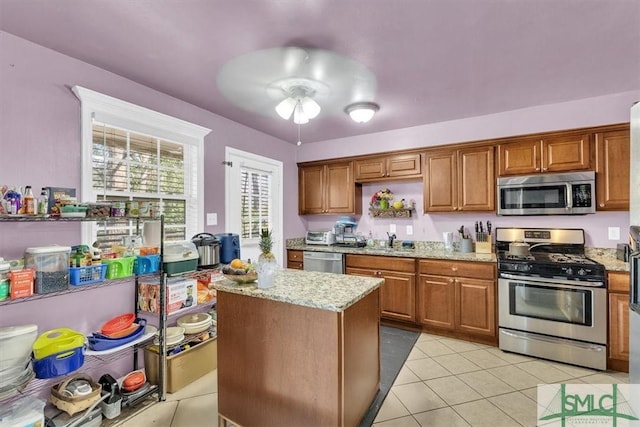 kitchen featuring light tile patterned floors, brown cabinets, and appliances with stainless steel finishes