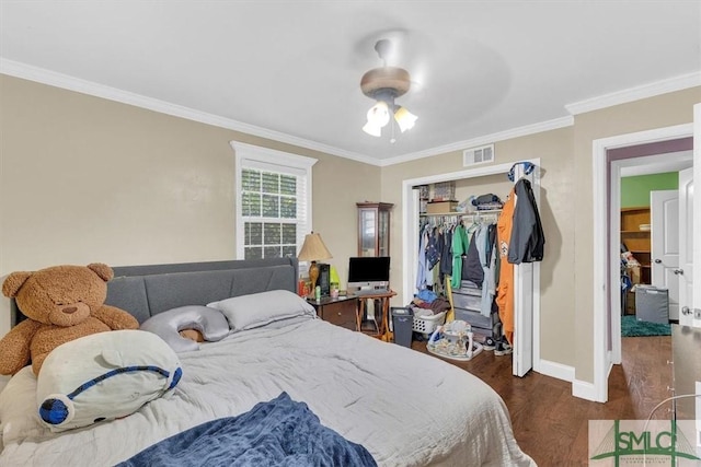 bedroom with baseboards, visible vents, ornamental molding, dark wood-type flooring, and a closet