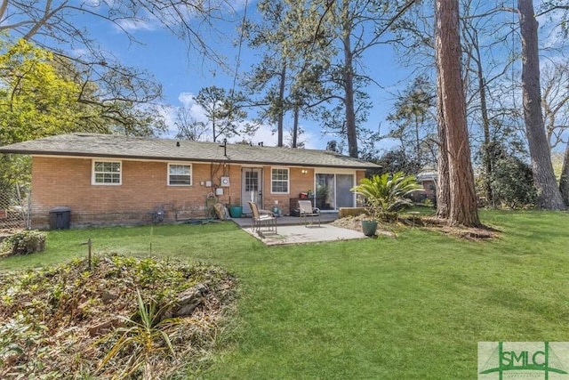 rear view of house featuring a yard, brick siding, and a patio