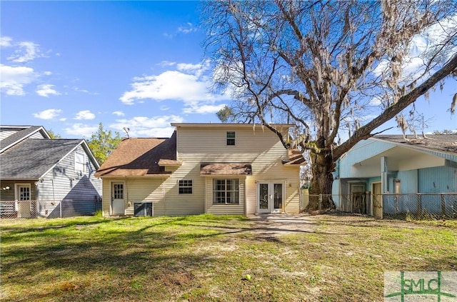 back of house with fence, french doors, and a lawn