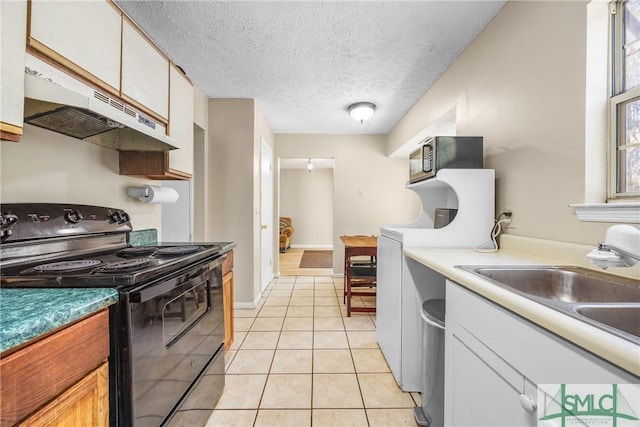 kitchen featuring black electric range, stainless steel microwave, under cabinet range hood, a sink, and light tile patterned flooring