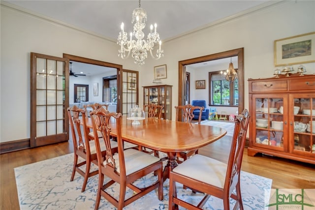 dining room featuring baseboards, wood finished floors, a chandelier, and crown molding