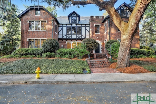 english style home featuring brick siding