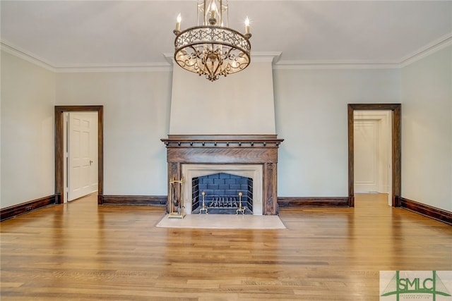 unfurnished living room with a chandelier, wood finished floors, baseboards, and ornamental molding